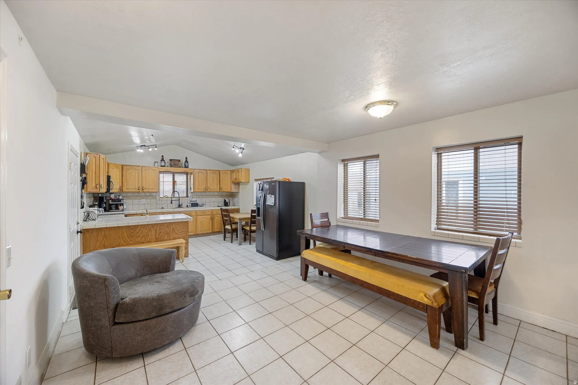 Dining space with vaulted ceiling and light tile patterned floors