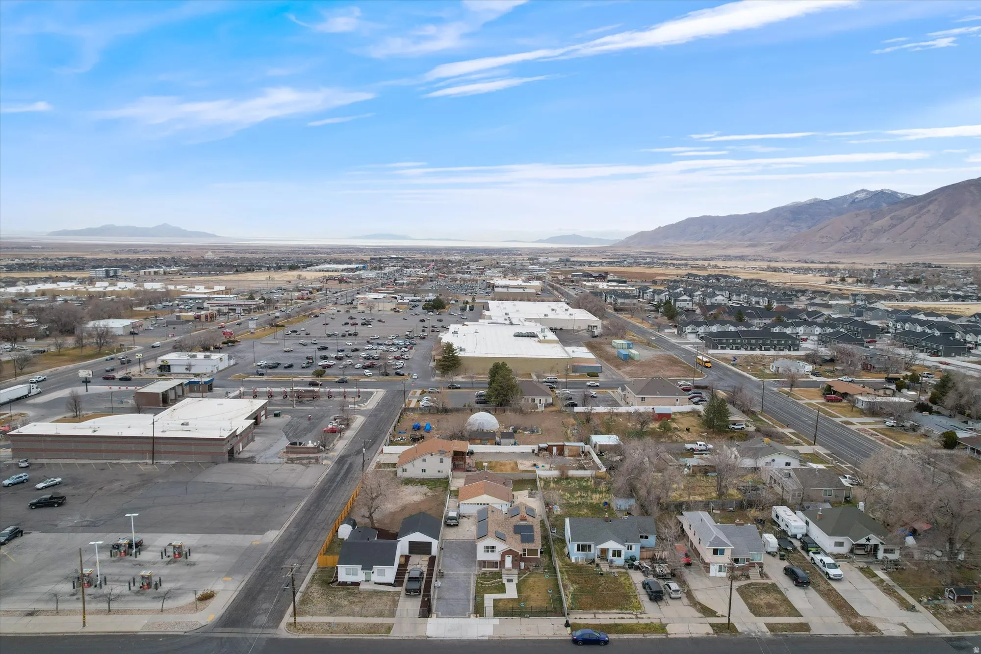 Aerial view of property's location featuring a mountain backdrop and nearby suburban area