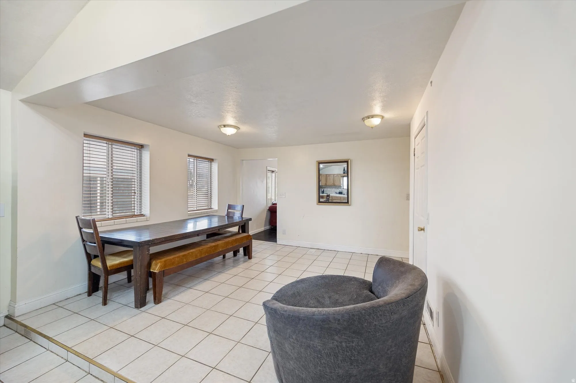 Dining area with light tile patterned floors and lofted ceiling