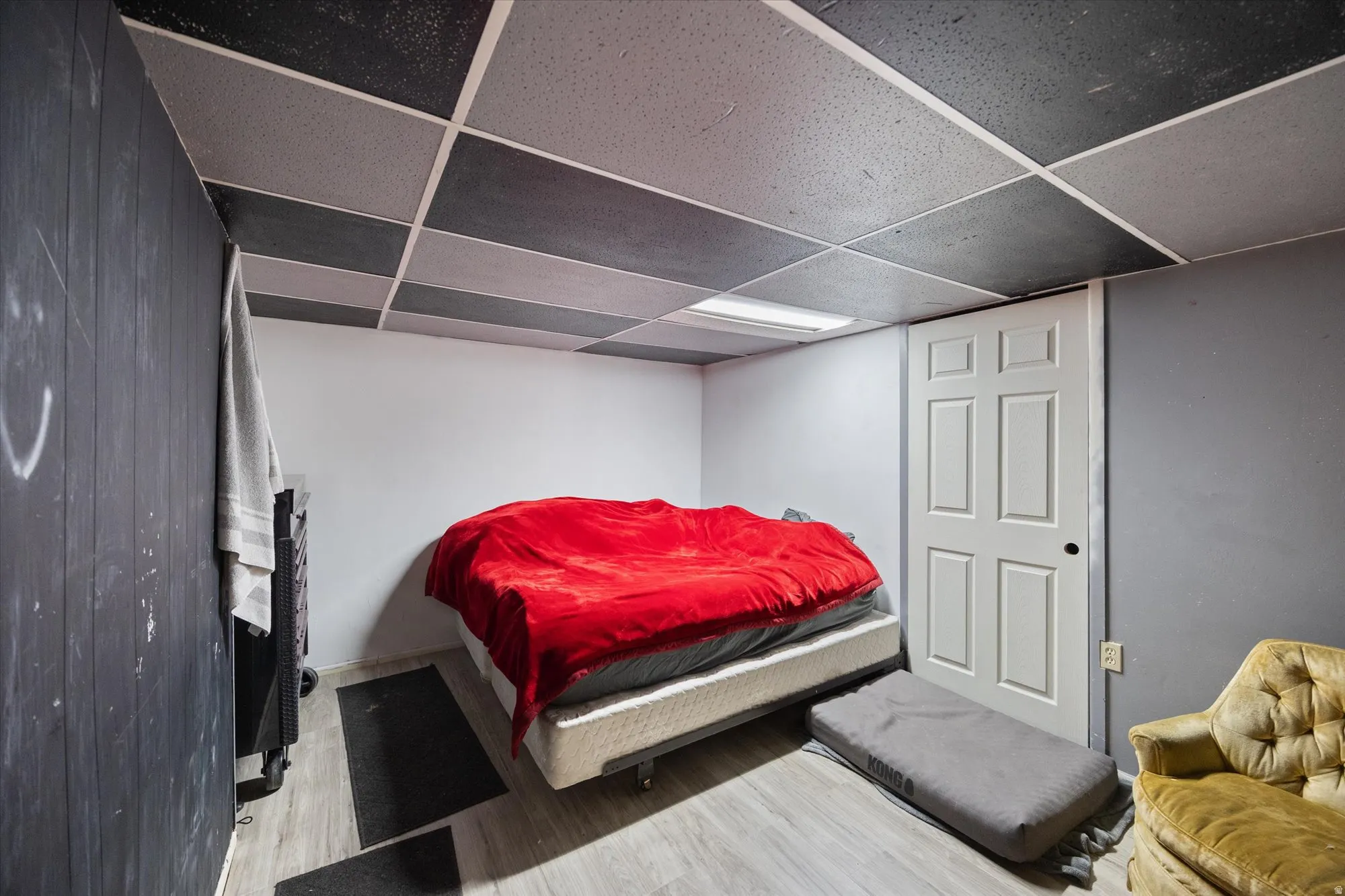 Bedroom with light wood-style floors and a paneled ceiling