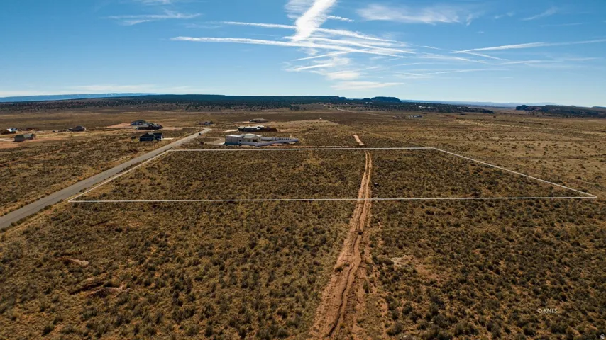Aerial view of sparsely populated area featuring a mountain backdrop and a desert landscape