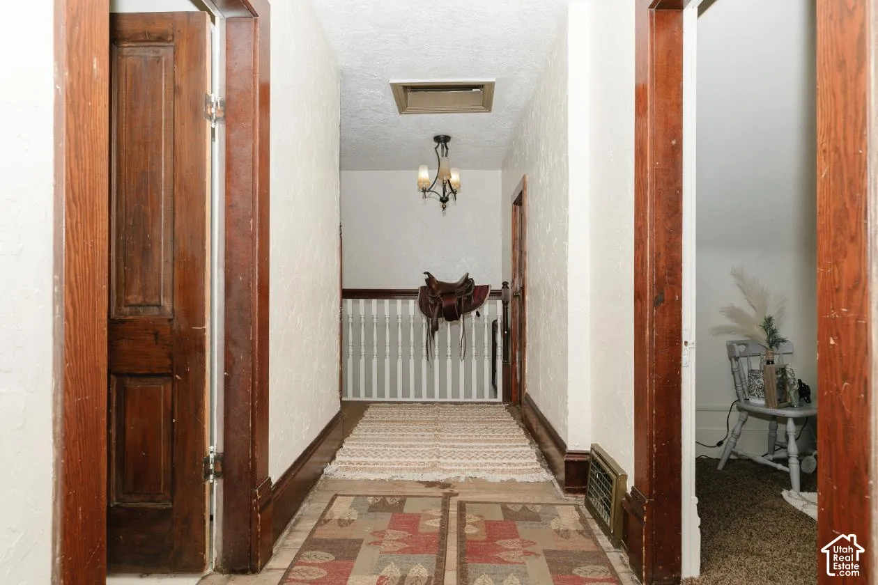 Hallway featuring a textured ceiling and baseboards