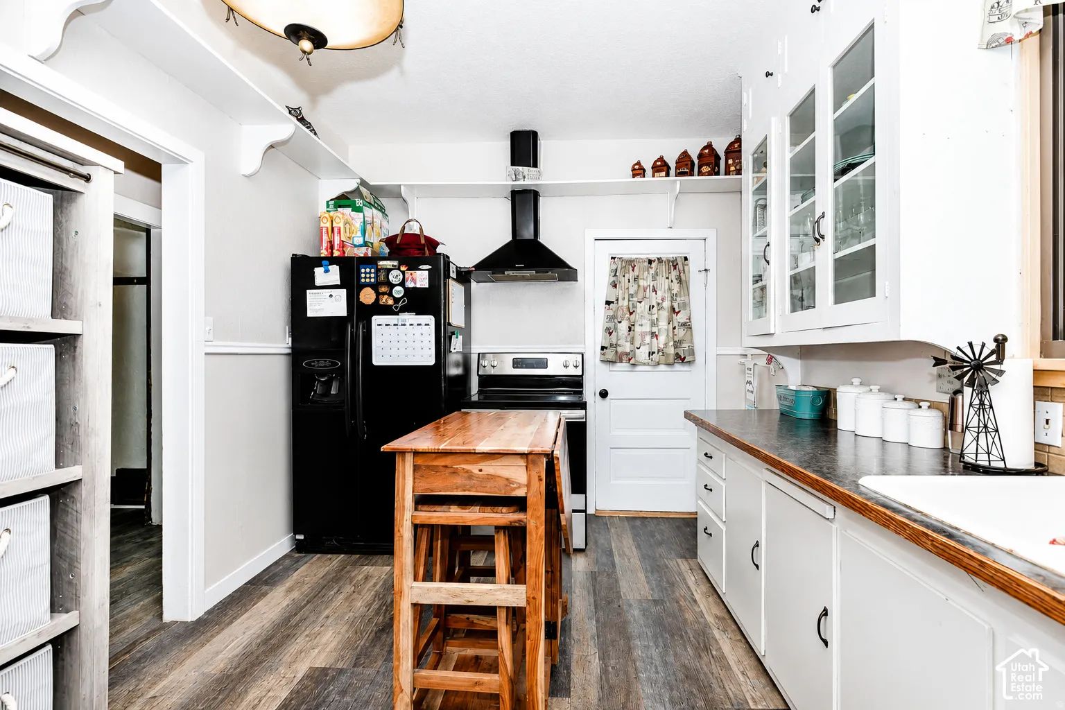 Kitchen featuring wood-finish flooring and white cabinetry