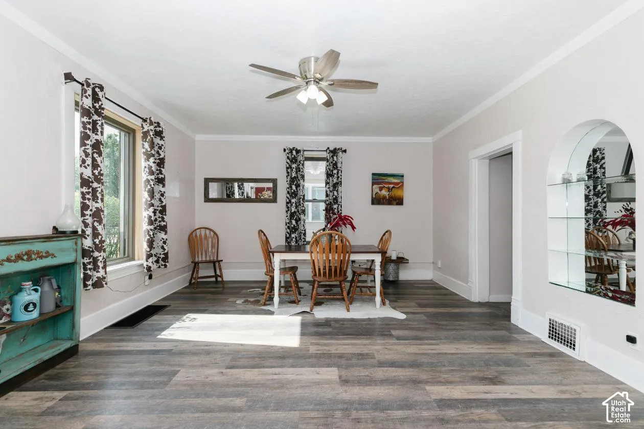 Dining space with a ceiling fan, wood finished floors, and crown molding