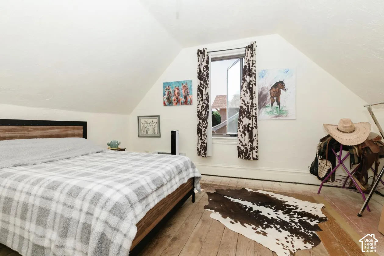 Bedroom featuring hardwood / wood-style floors and baseboards