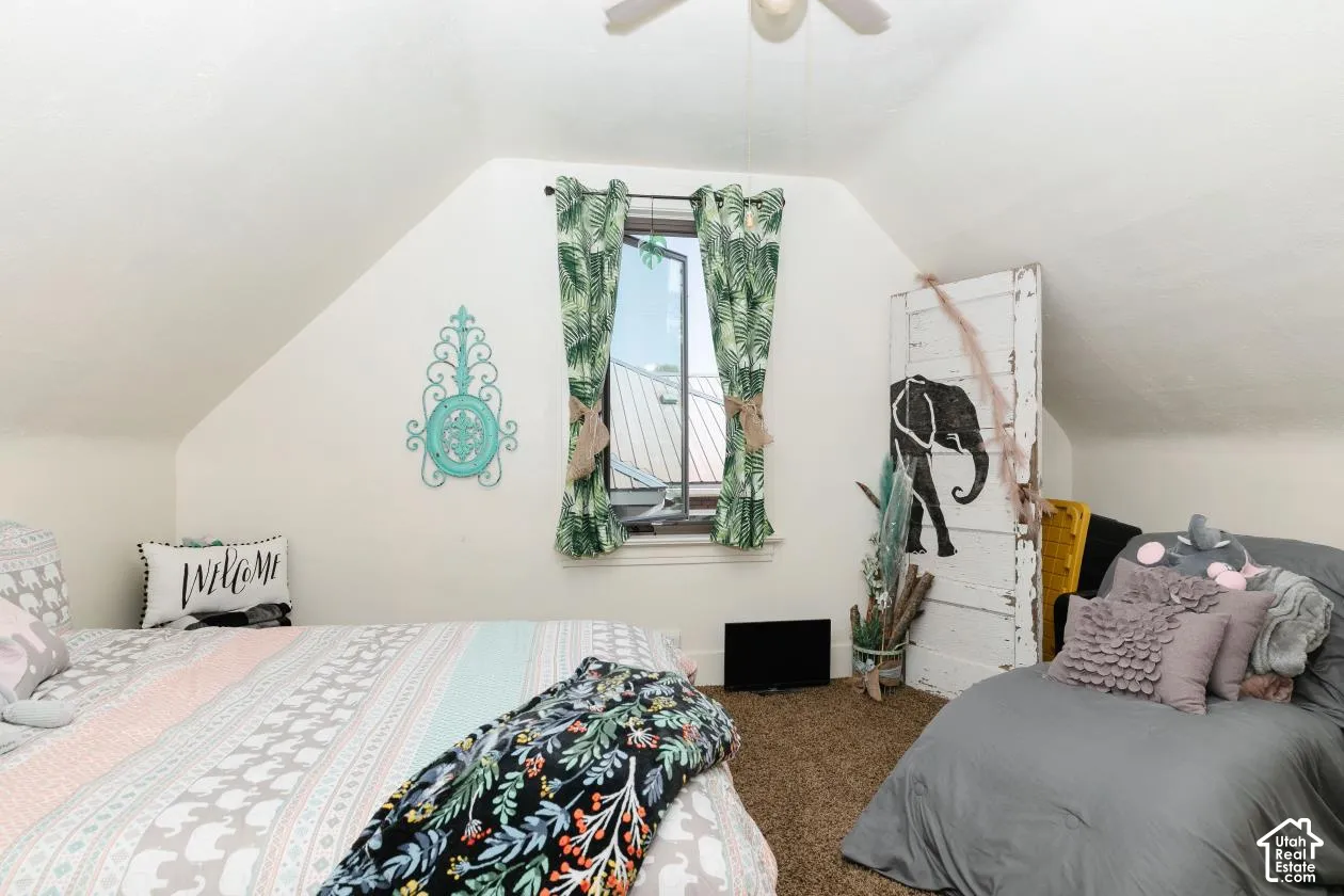 Bedroom with lofted ceiling, carpet, and a ceiling fan
