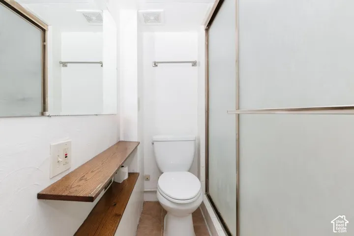 Full bath featuring toilet and tile patterned flooring