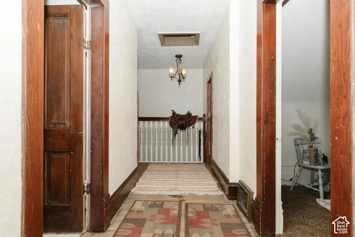 Hallway featuring a textured ceiling and baseboards