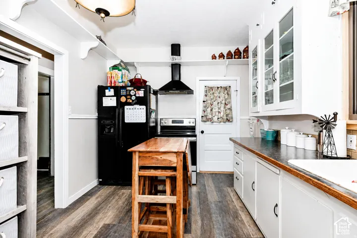 Kitchen featuring wood-finish flooring and white cabinetry