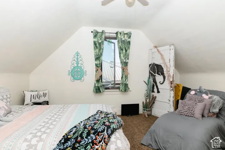 Bedroom with lofted ceiling, carpet, and a ceiling fan