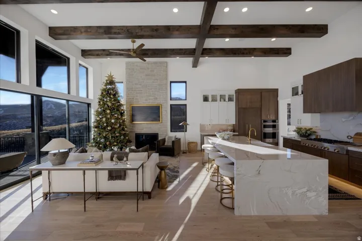 Living room featuring recessed lighting, light wood-type flooring, a large fireplace, and ceiling fan