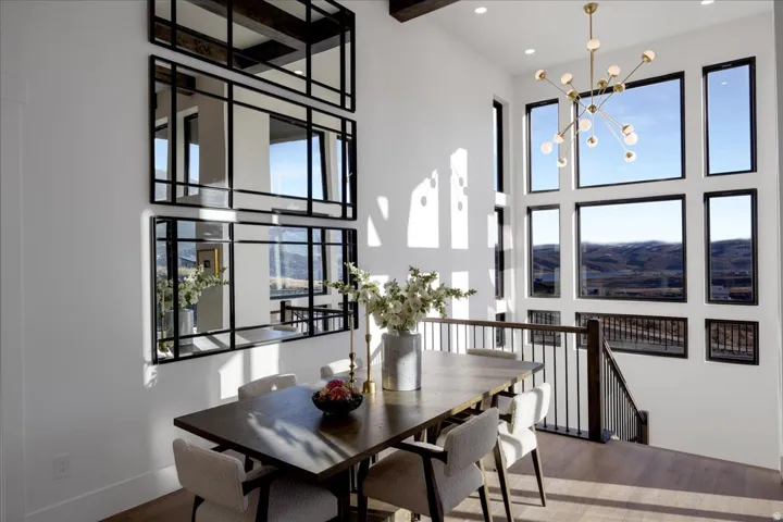 Dining room with wood finished floors, a high ceiling, and suspended lighting