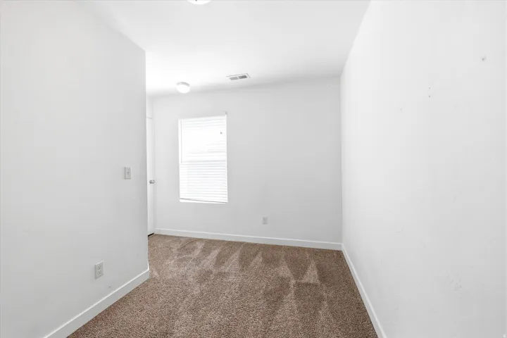 Neutral wall finishes and brown carpeting