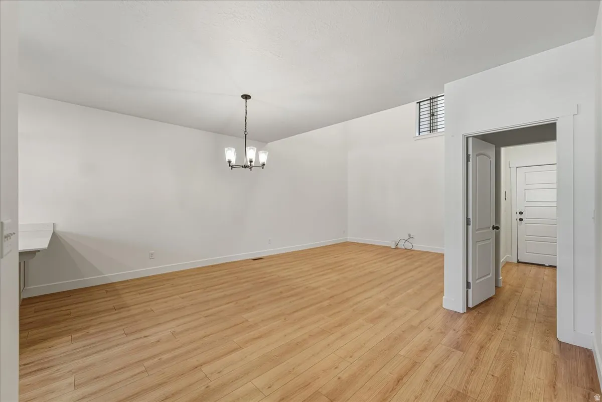 Unfurnished dining area featuring light wood finished floors and hanging lights