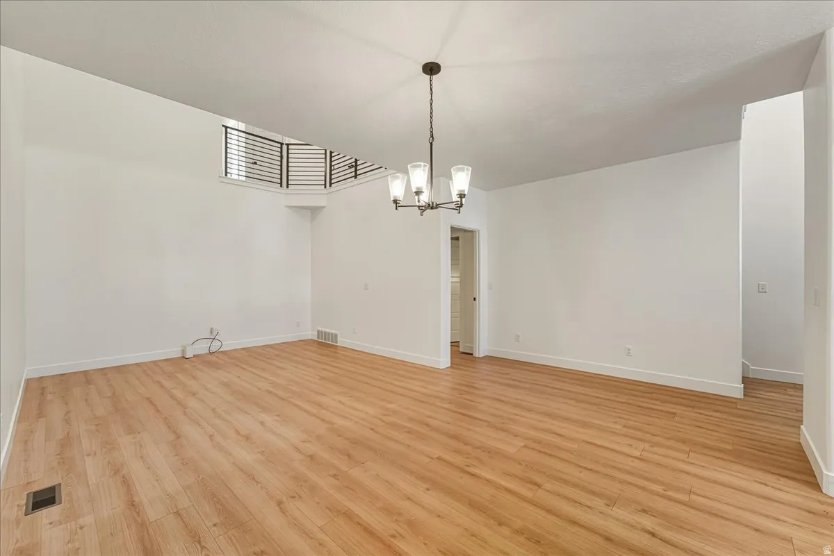 Unfurnished dining area featuring light wood-style floors and a chandelier