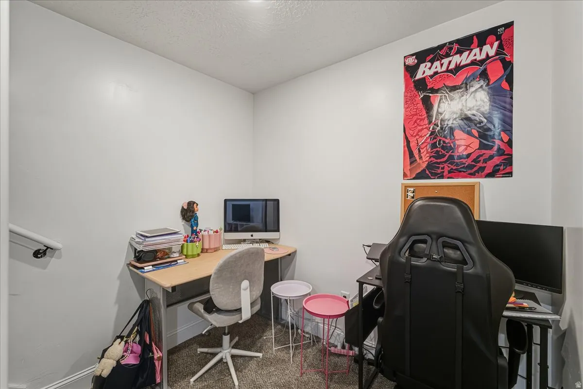 Office area featuring a textured ceiling and dark carpet