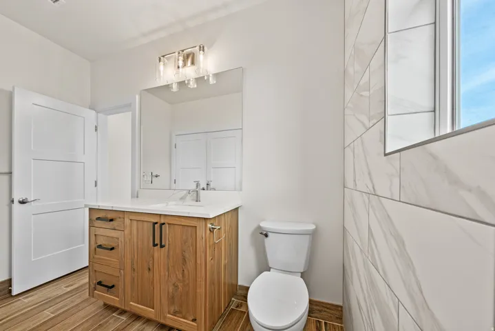 Half bathroom featuring vanity and wood finish floors