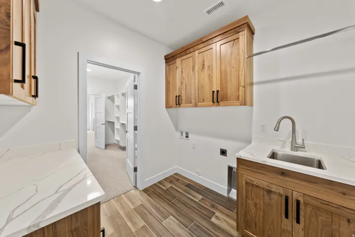 Laundry room with cabinet space, wood tiled floors, hookup for an electric dryer, hookup for a washing machine, and recessed lighting