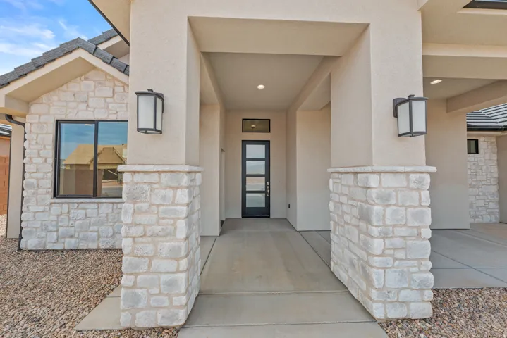 Doorway to property with stone siding and stucco siding