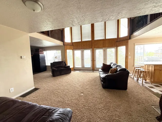 Living area with carpet and a high textured ceiling