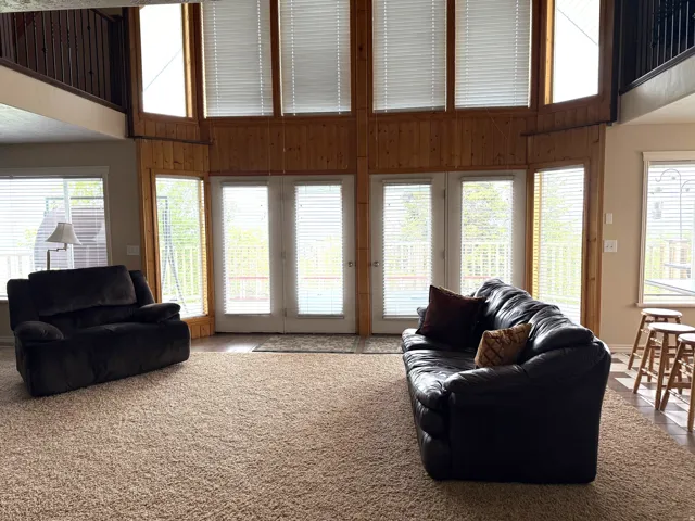 Carpeted living area with a high ceiling