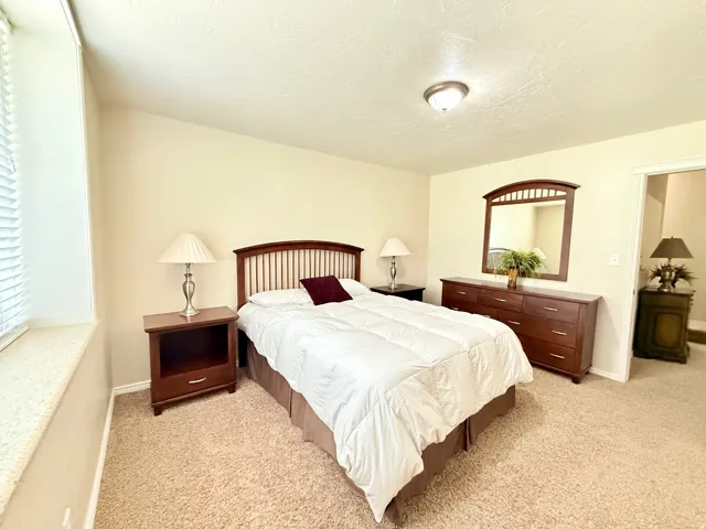 Bedroom featuring light carpet and a textured ceiling