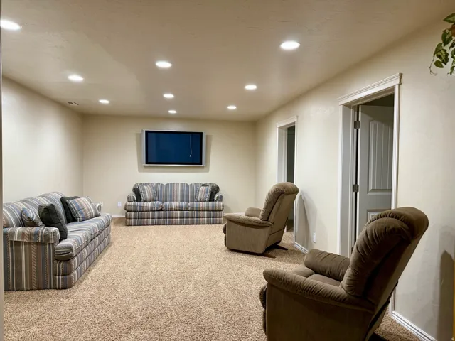 Carpeted living area featuring recessed lighting and baseboards