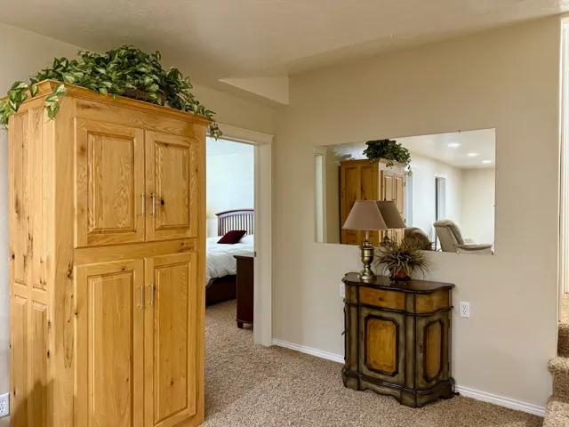 Hallway featuring light carpet and baseboards