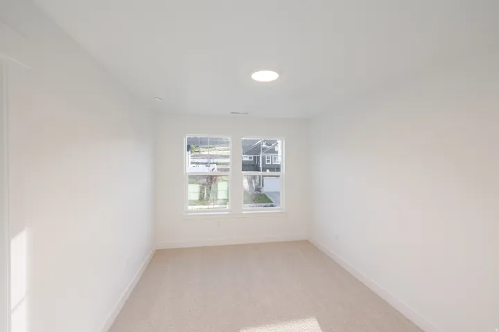 Carpeted room featuring two large windows, white walls, and a recessed ceiling light