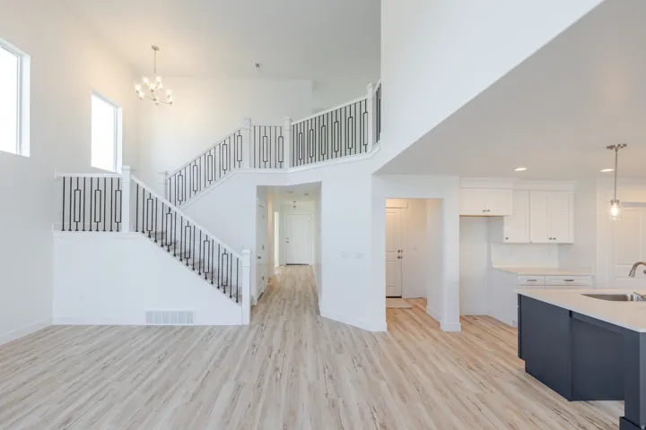 Two-story entryway with a modern chandelier and wood-finish flooring