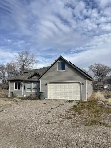 View of front facade with driveway, a garage, and roof with shingles
