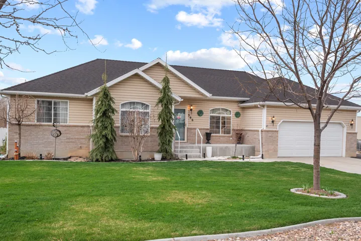Ranch-style home with brick siding, a front lawn, a garage, and concrete driveway