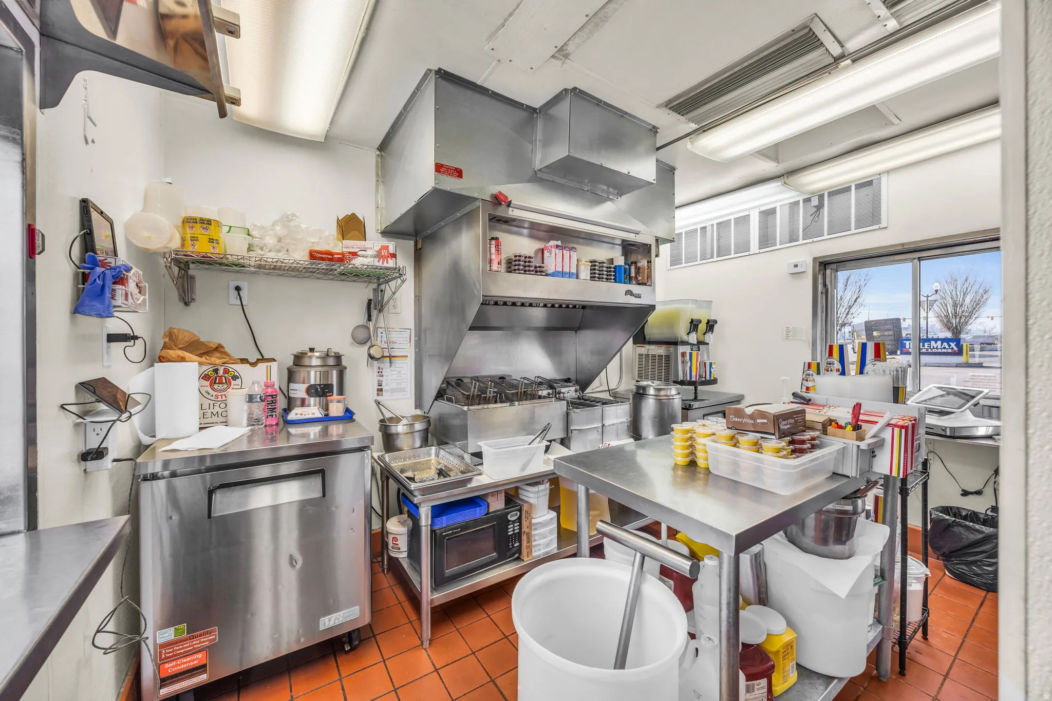 Kitchen with stainless steel countertops and black microwave