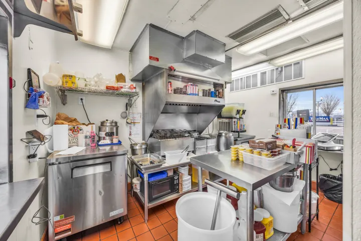 Kitchen with stainless steel countertops and black microwave