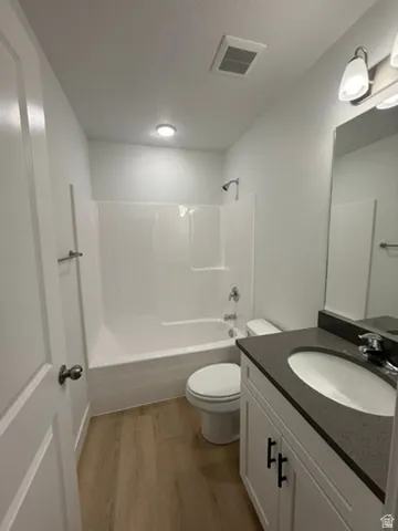 Full bathroom with light wood-style floors, vanity, and shower / bathtub combination
