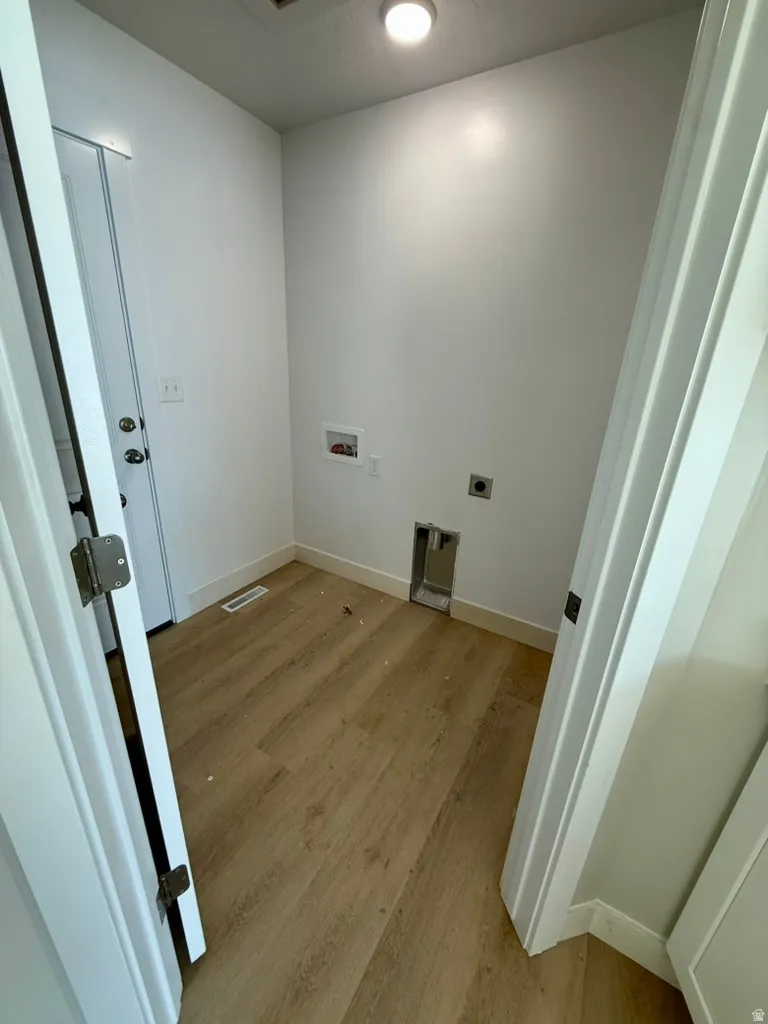 Laundry room featuring hookup for a washing machine, light wood-style floors, and electric dryer hookup