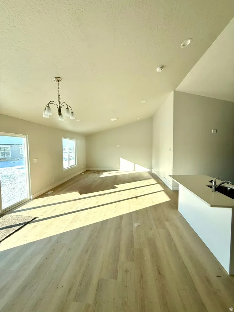 Additional living space with a chandelier and light wood-style floors