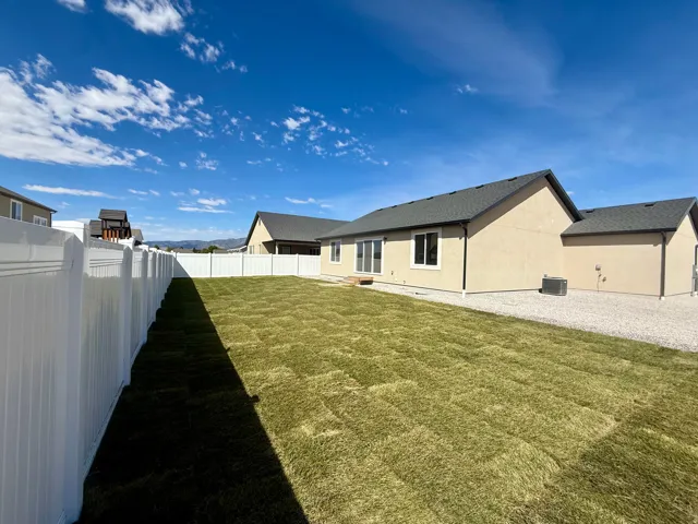 Expansive backyard featuring newly laid sod, and a gravel side yard