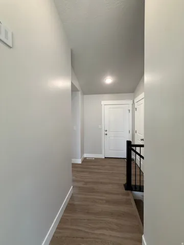 lvp throughout, white interior doors, recessed lighting, and a black wrought iron staircase railing