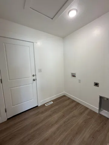 Recessed ceiling light, white walls, lvp, white trim, and a paneled door