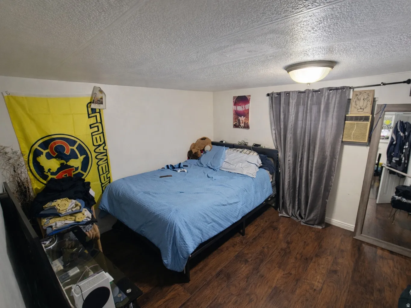 Bedroom with dark wood-type flooring and a textured ceiling