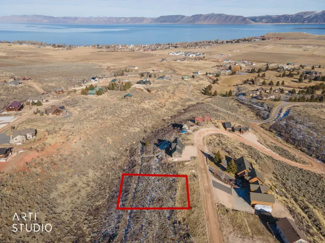 Aerial view of property's location featuring nearby suburban area, a water and mountain view, and property parcel outlined
