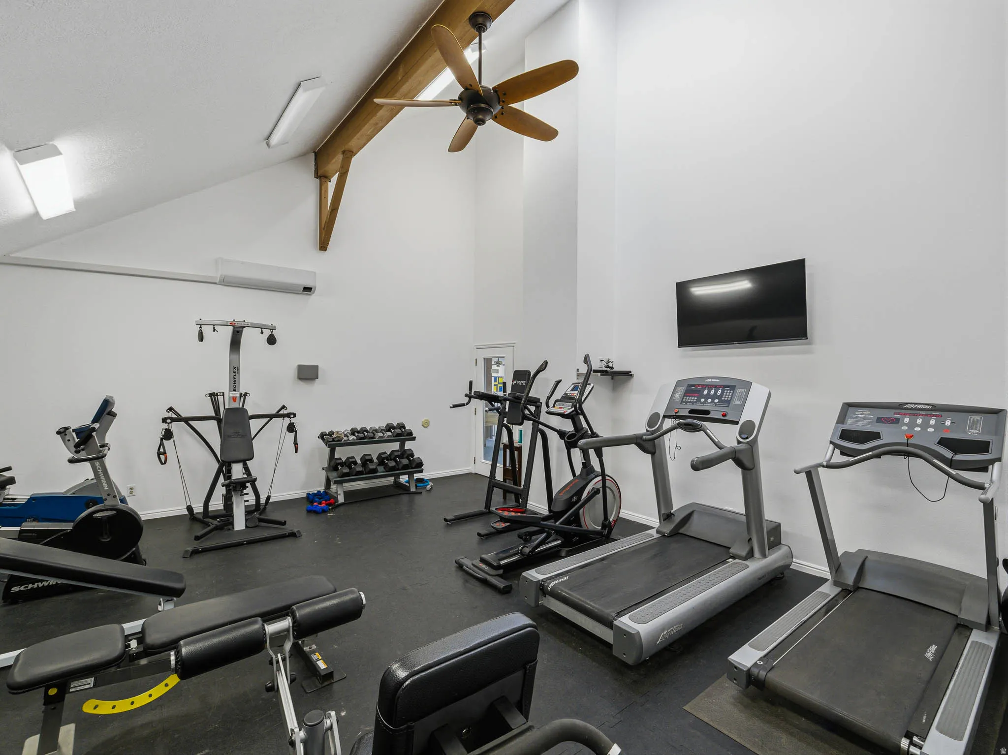 Exercise room featuring ceiling fan and lofted ceiling