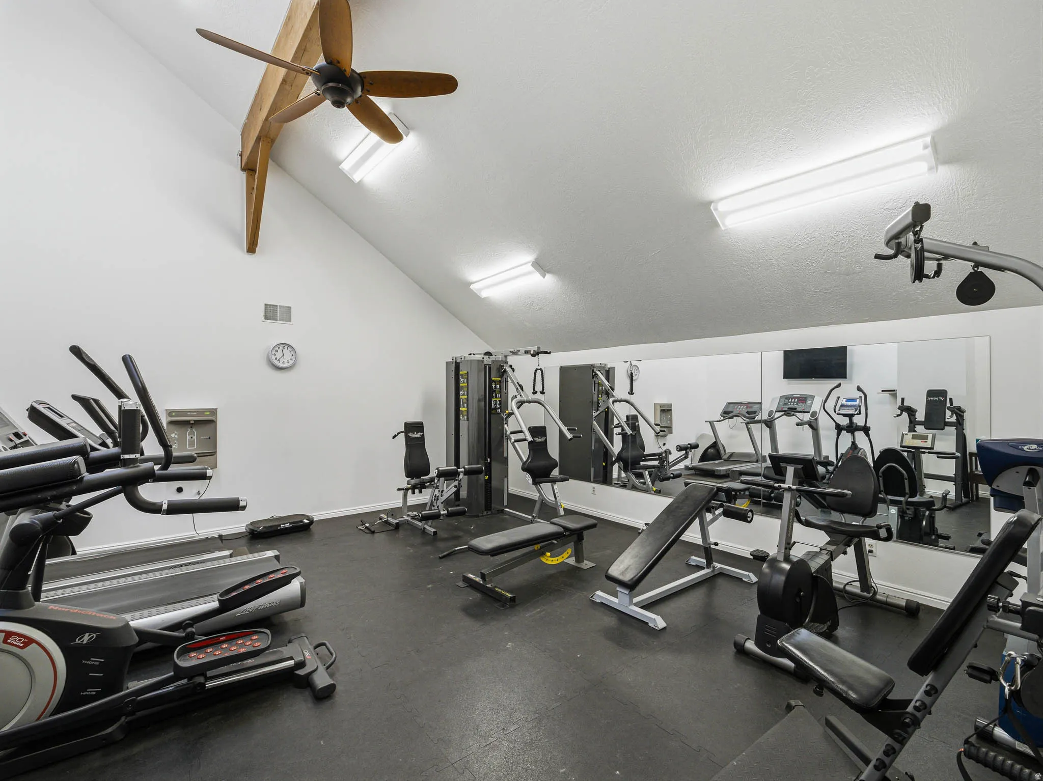Workout area with lofted ceiling and a ceiling fan