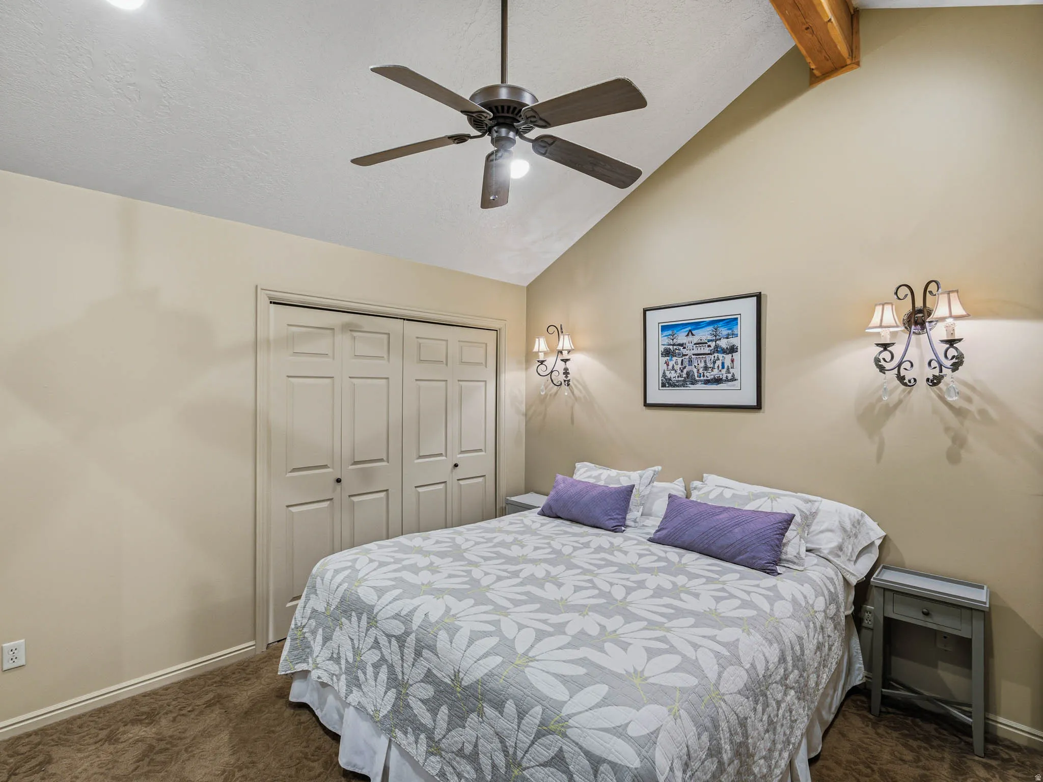 Bedroom featuring lofted ceiling with beams, dark carpet, a closet, and a ceiling fan