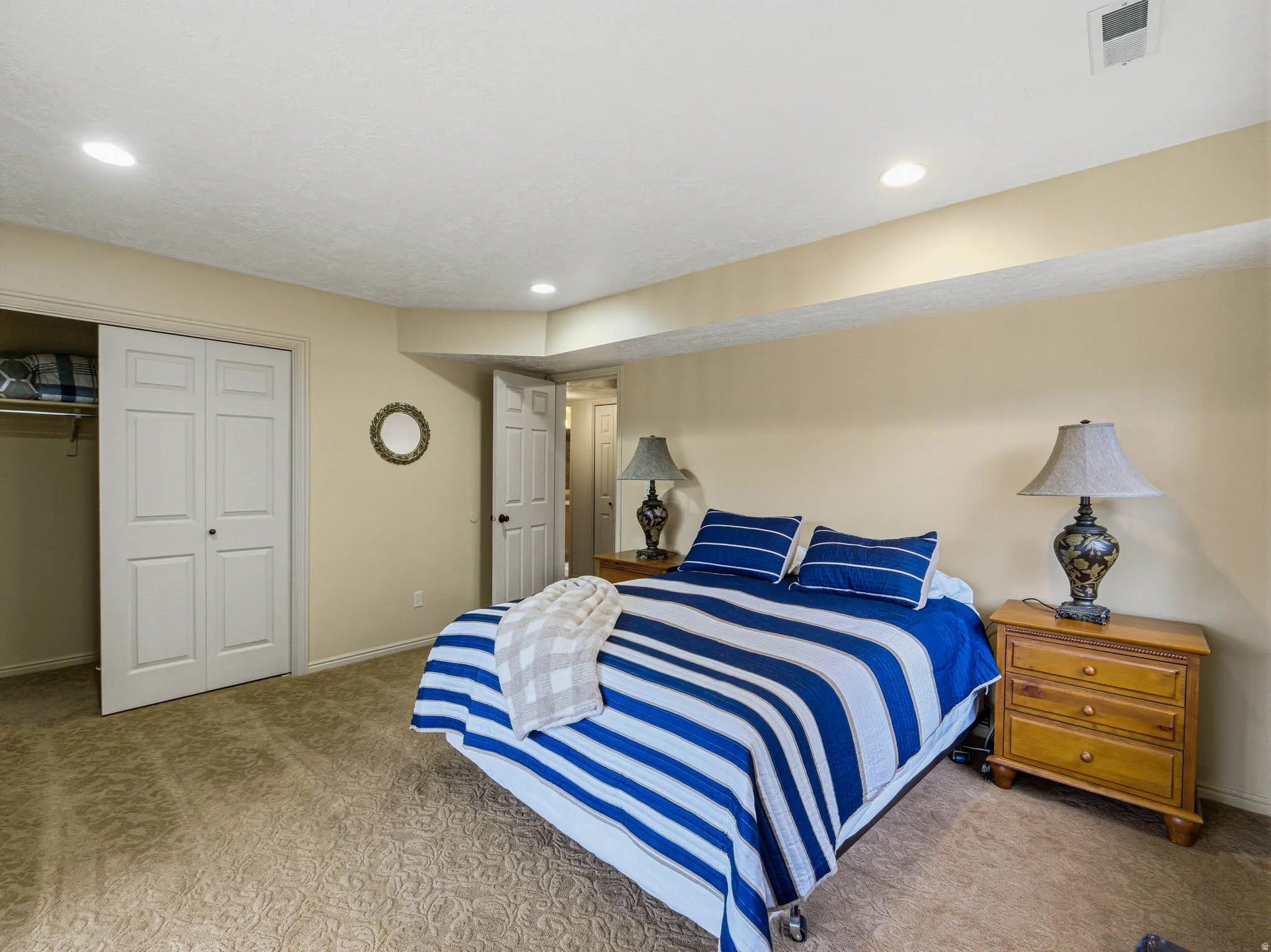 Bedroom with light colored carpet, a closet, and recessed lighting