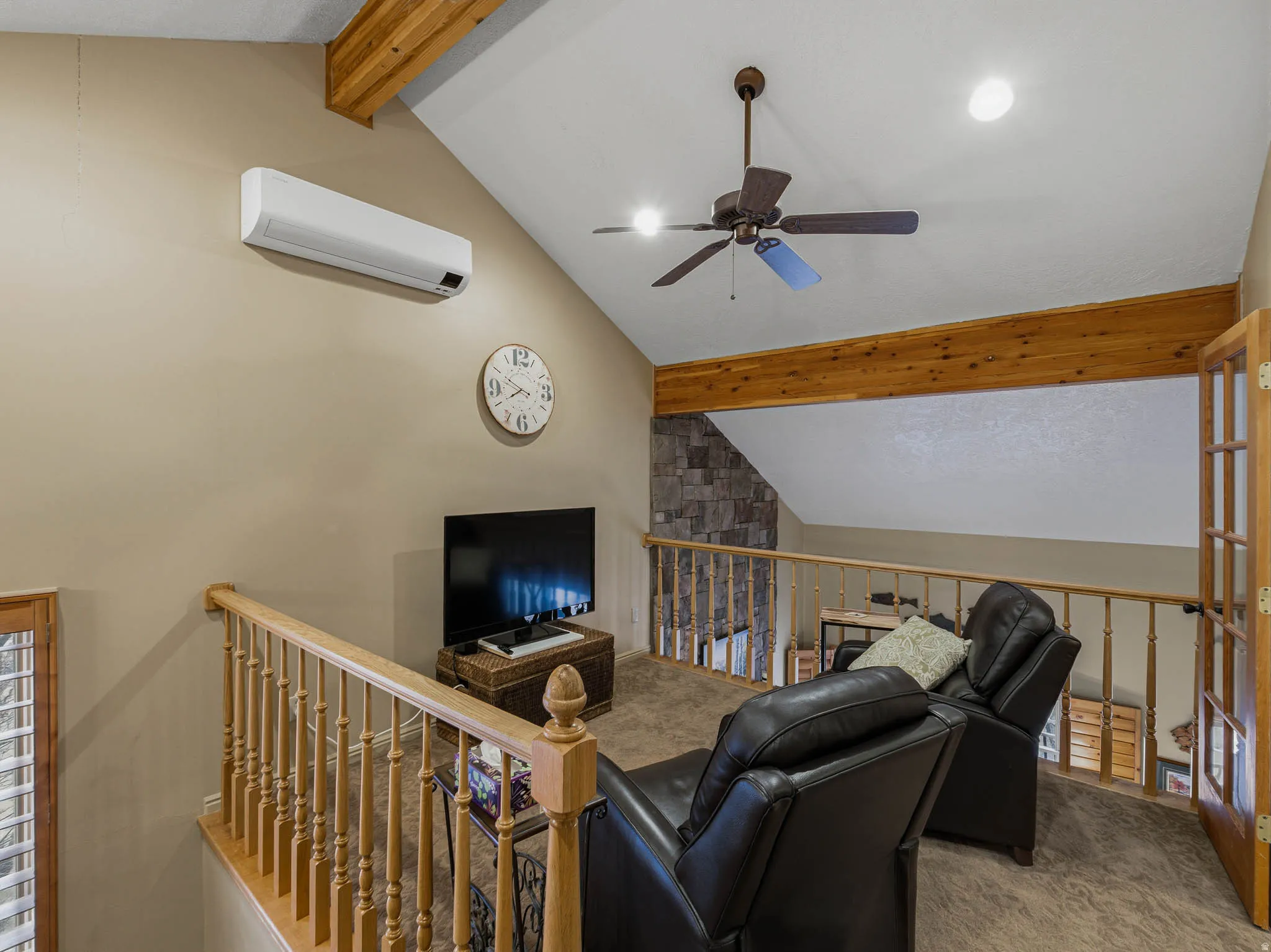 Carpeted living area with beamed ceiling, a ceiling fan, and a mini split for heating / cooling