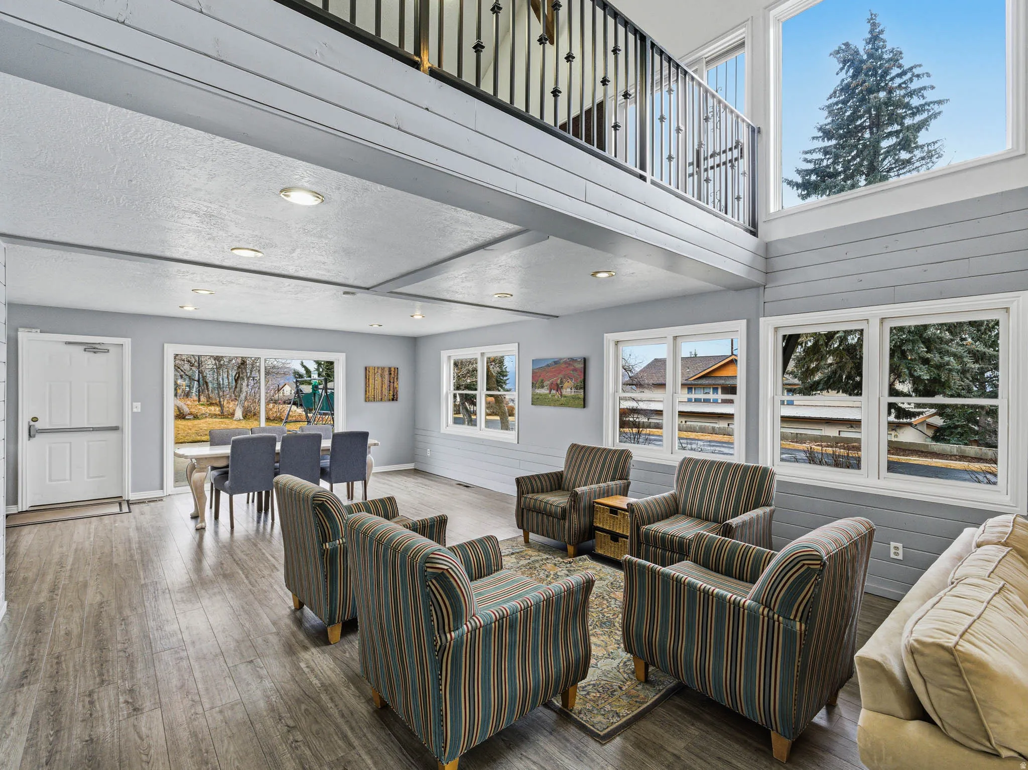 Living room with hardwood / wood-style floors, a high ceiling, and recessed lighting