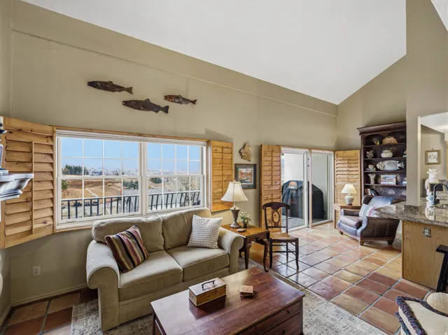Tiled living area featuring lofted ceiling and a sink