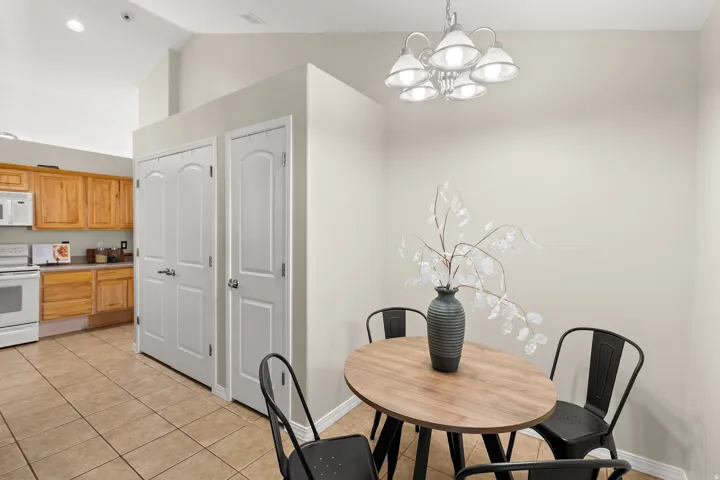 Dining room with light tile patterned floors, hanging lights, and lofted ceiling